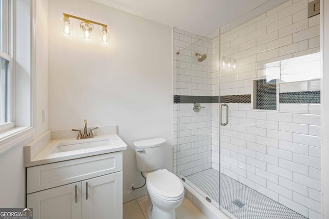 bathroom featuring vanity, toilet, and a shower stall