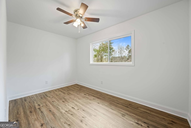 spare room with a ceiling fan, baseboards, and wood finished floors