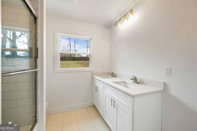 full bathroom with tile patterned flooring, toilet, baseboards, and a sink