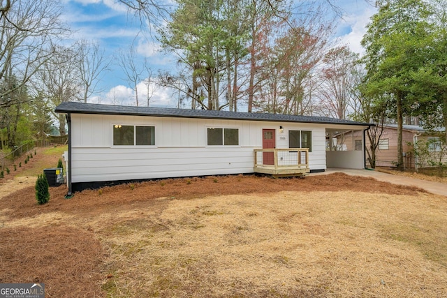 ranch-style house featuring a carport, cooling unit, and board and batten siding