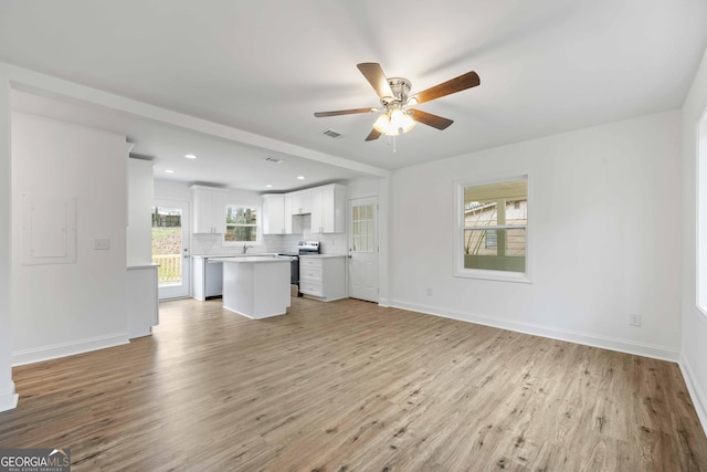 unfurnished living room featuring baseboards, light wood-style floors, visible vents, and ceiling fan