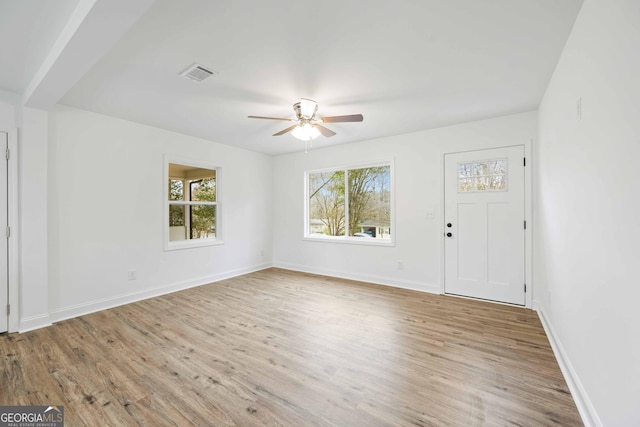 interior space featuring baseboards, wood finished floors, visible vents, and ceiling fan