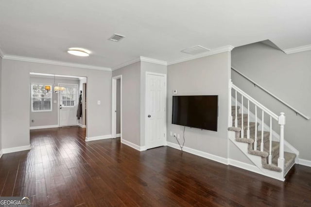 unfurnished living room with visible vents, wood finished floors, crown molding, baseboards, and stairs