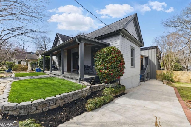 view of property exterior featuring a yard, fence, and covered porch