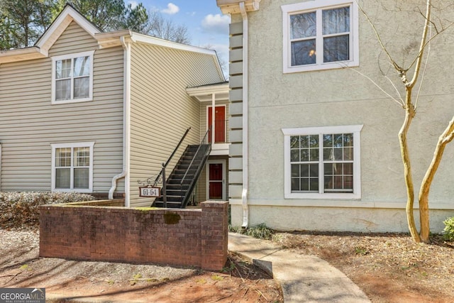 view of front facade featuring stucco siding and stairs