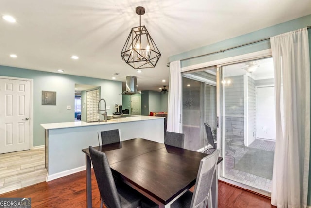 dining space with recessed lighting, light wood-type flooring, baseboards, and a notable chandelier