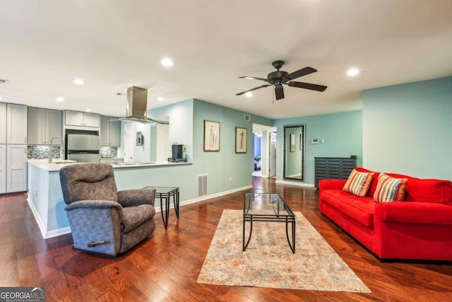 living area with a ceiling fan, visible vents, baseboards, recessed lighting, and dark wood-type flooring