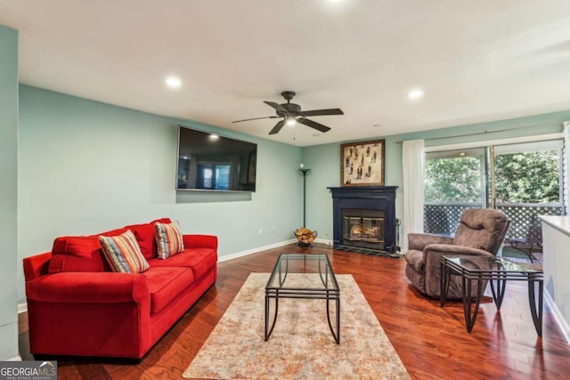 living room featuring baseboards, a fireplace with flush hearth, recessed lighting, dark wood-style floors, and a ceiling fan