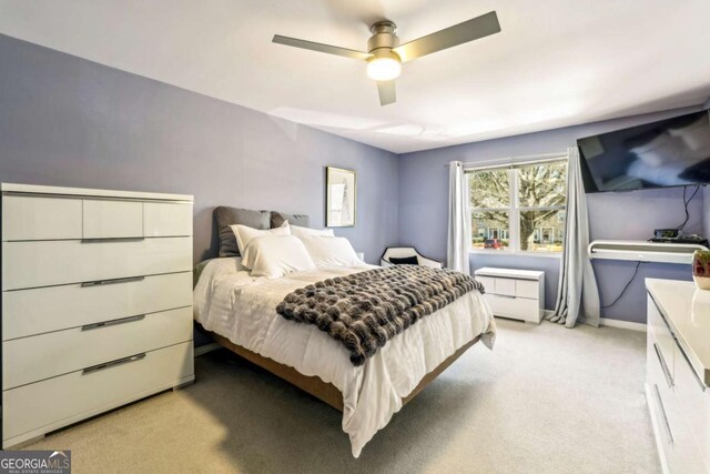 bedroom with baseboards, a ceiling fan, and light colored carpet