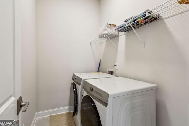 laundry area featuring baseboards, separate washer and dryer, and laundry area