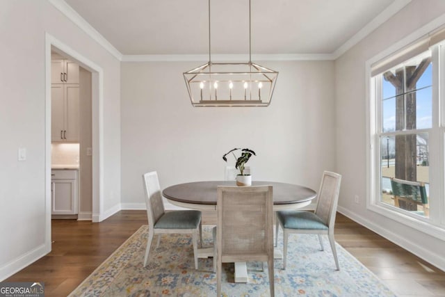 dining space with dark wood finished floors, a notable chandelier, baseboards, and ornamental molding