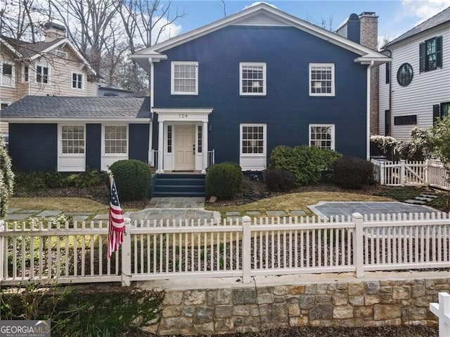 view of front of property featuring a fenced front yard and a chimney