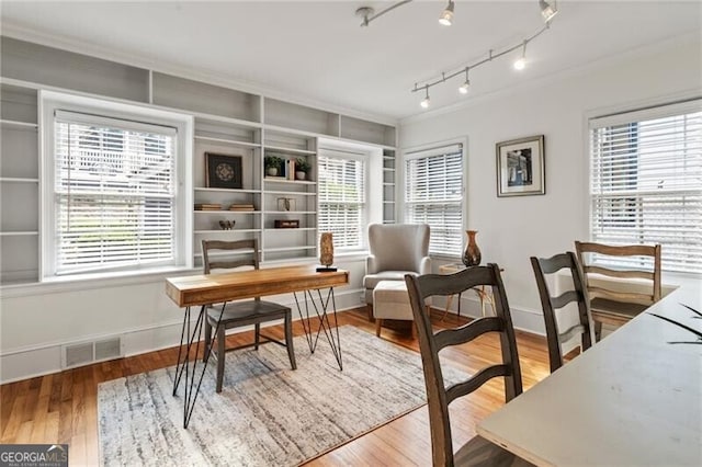 office space featuring a wealth of natural light, visible vents, and wood finished floors