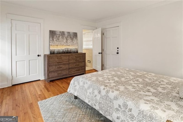 bedroom with wood finished floors and ornamental molding