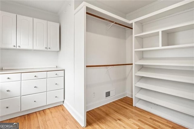 spacious closet with light wood-style flooring and visible vents