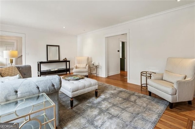 living room featuring wood finished floors, baseboards, and ornamental molding