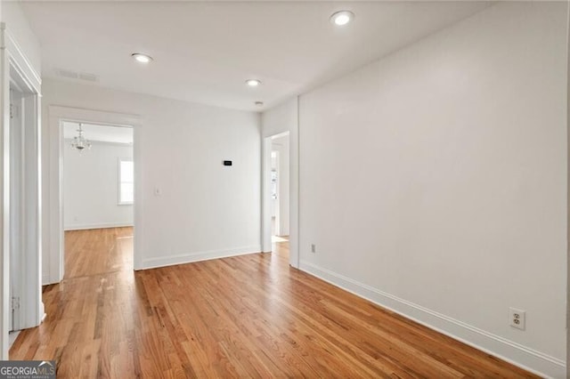 unfurnished room featuring light wood-type flooring, visible vents, recessed lighting, an inviting chandelier, and baseboards