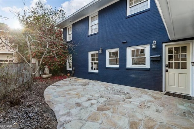 rear view of property featuring a patio and fence