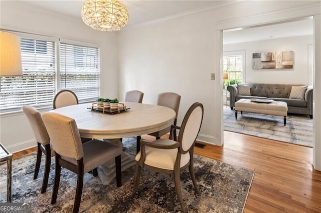 dining room with baseboards, wood finished floors, and crown molding