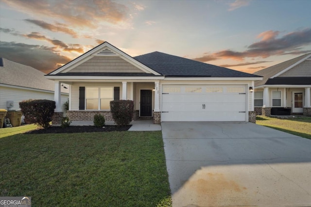 craftsman-style house featuring a shingled roof, a front lawn, concrete driveway, a garage, and brick siding