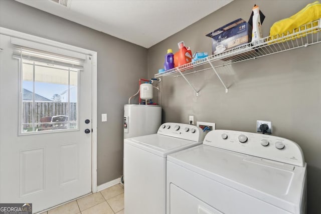 washroom featuring baseboards, light tile patterned floors, laundry area, water heater, and washer and dryer