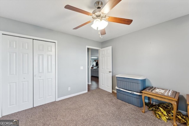 bedroom with a closet, baseboards, a ceiling fan, and carpet flooring