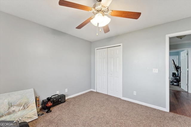 bedroom featuring a closet, a ceiling fan, baseboards, and dark colored carpet