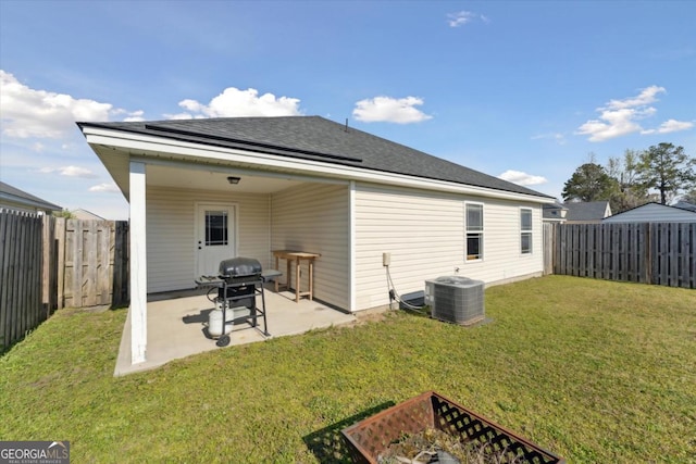 back of property featuring a yard, a patio area, a fenced backyard, and central AC