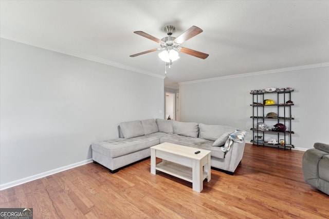 living room featuring baseboards, wood finished floors, a ceiling fan, and ornamental molding