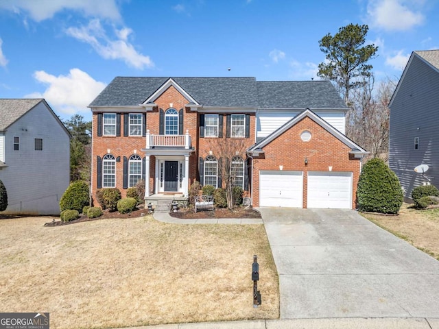 view of front of house with a balcony, roof with shingles, concrete driveway, a front lawn, and brick siding