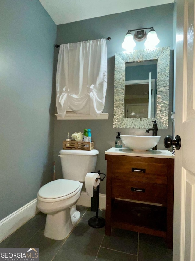 bathroom featuring baseboards, toilet, vanity, and tile patterned flooring