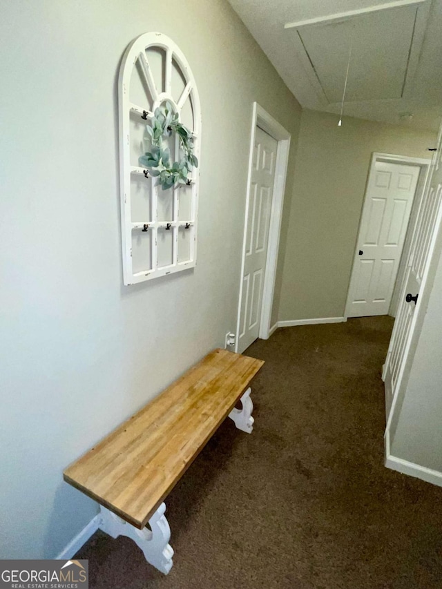 corridor featuring attic access, carpet flooring, and baseboards