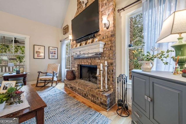 4770 Hilltop Dr NW, Acworth, GA 30101 - living area featuring plenty of natural light, a fireplace, light wood-style floors, and lofted ceiling