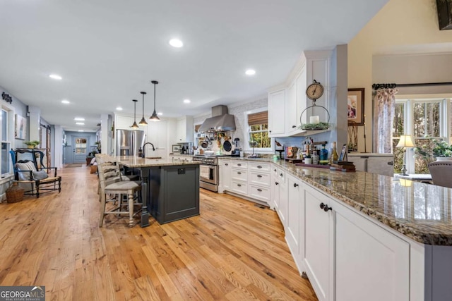 4770 Hilltop Dr NW, Acworth, GA 30101 - kitchen with appliances with stainless steel finishes, wall chimney range hood, light wood-style floors, white cabinets, and recessed lighting