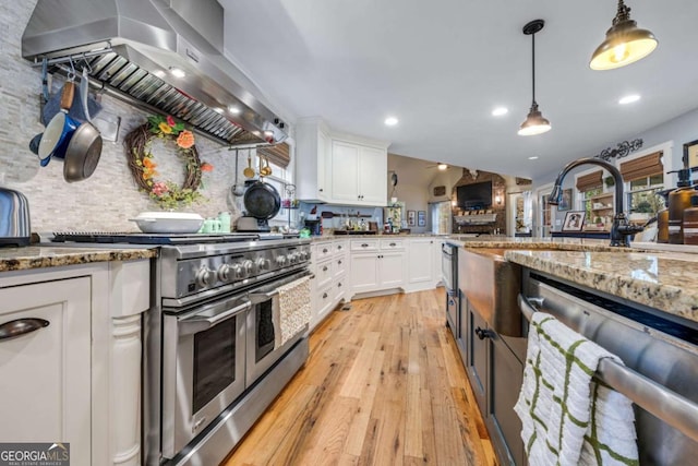 4770 Hilltop Dr NW, Acworth, GA 30101 - kitchen with stainless steel appliances, extractor fan, light wood finished floors, white cabinetry, and light stone counters