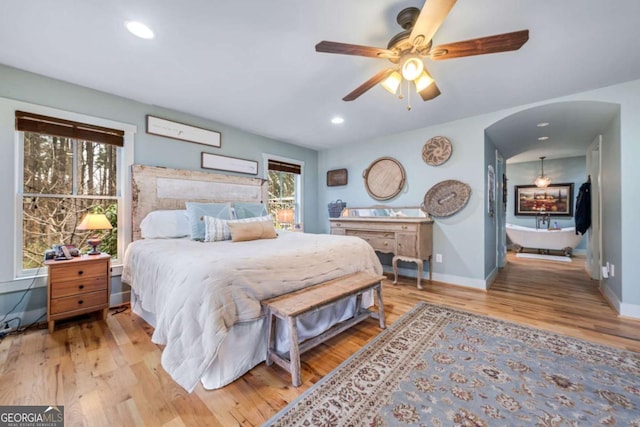 4770 Hilltop Dr NW, Acworth, GA 30101 - bedroom with light wood-style flooring, arched walkways, recessed lighting, and ceiling fan
