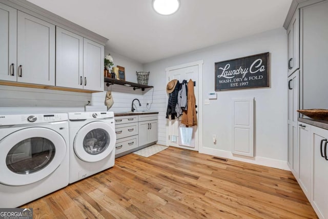4770 Hilltop Dr NW, Acworth, GA 30101 - washroom with cabinet space, light wood-style floors, and washing machine and dryer