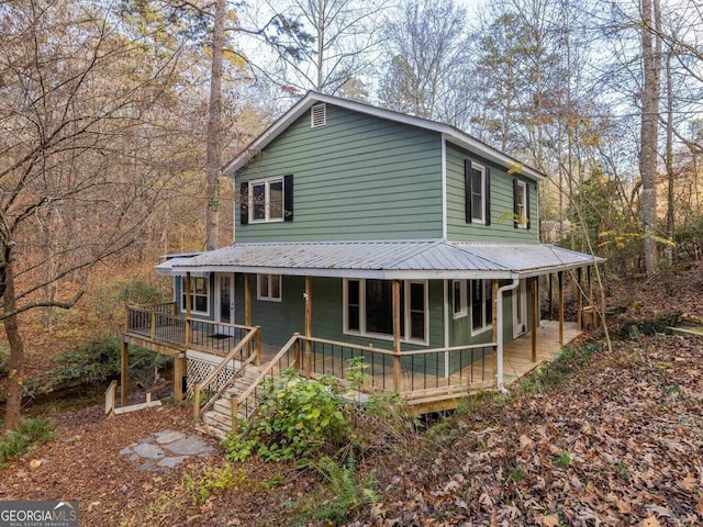 farmhouse-style home with a porch and metal roof