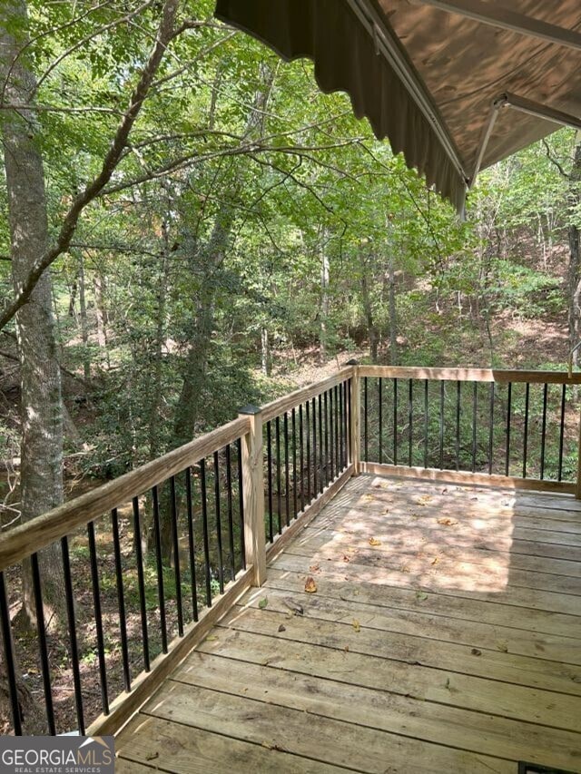 wooden terrace featuring a view of trees