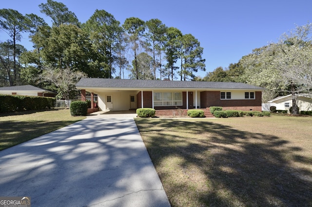 ranch-style home featuring driveway, brick siding, a carport, and a front yard