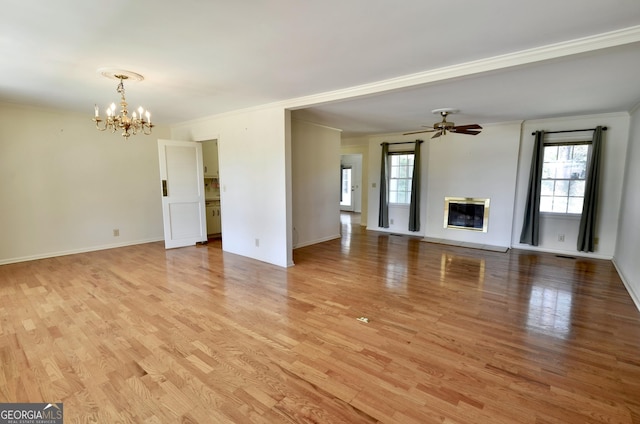 unfurnished living room featuring a healthy amount of sunlight, crown molding, and light wood-style floors