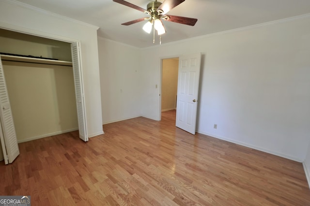 unfurnished bedroom featuring crown molding, light wood-style flooring, baseboards, and a closet