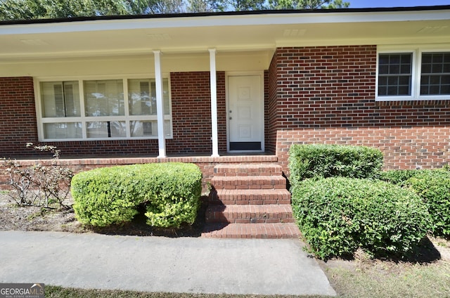 doorway to property with brick siding