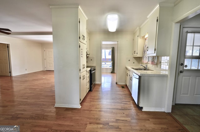 kitchen with a ceiling fan, a sink, stainless steel range with electric cooktop, tile countertops, and dishwashing machine