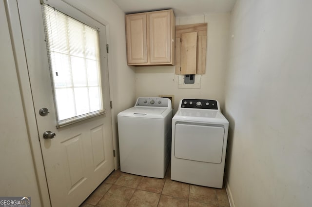 washroom with cabinet space, light tile patterned floors, washing machine and dryer, and baseboards