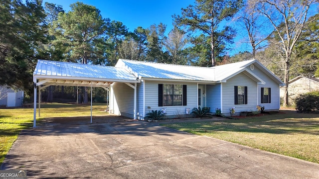 single story home with metal roof, an attached carport, concrete driveway, and a front yard