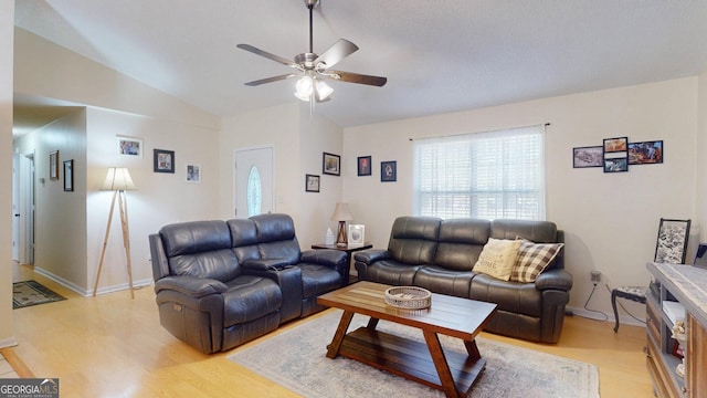 living area with light wood-style flooring, a ceiling fan, and vaulted ceiling