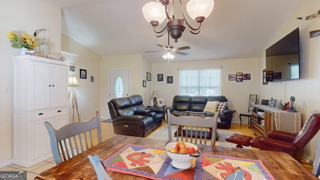 dining room featuring vaulted ceiling, light tile patterned floors, and ceiling fan with notable chandelier