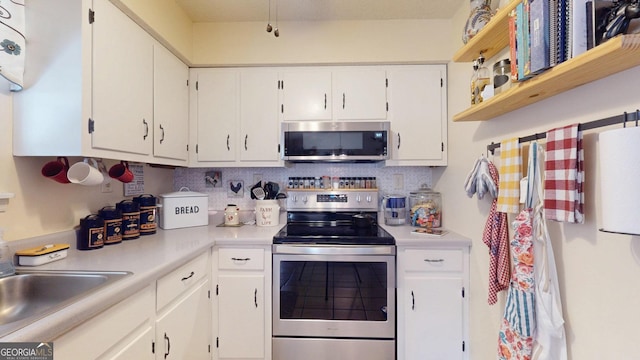 kitchen featuring open shelves, white cabinetry, appliances with stainless steel finishes, light countertops, and decorative backsplash