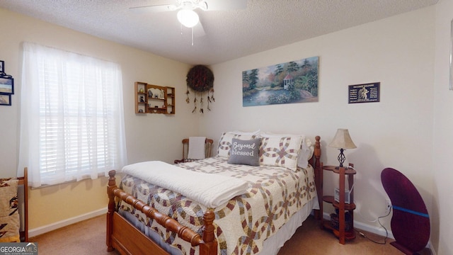 carpeted bedroom with a textured ceiling, baseboards, and a ceiling fan